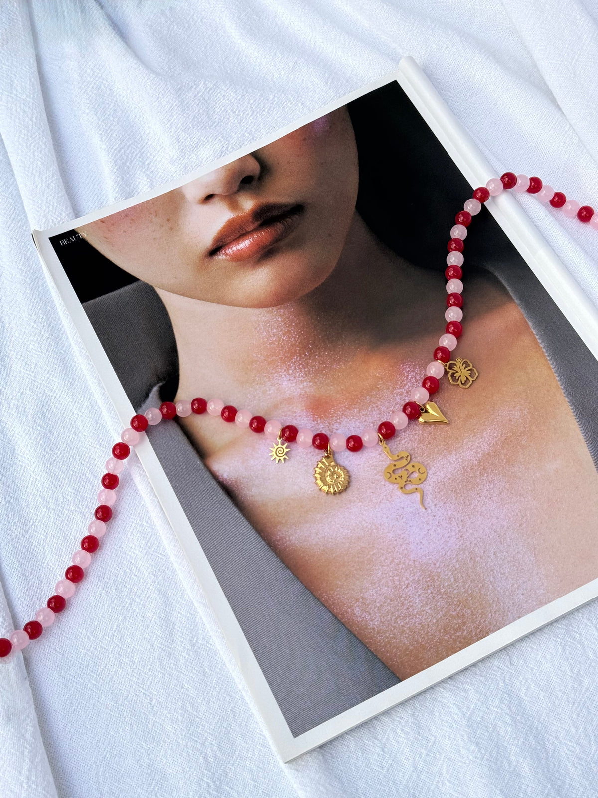 Gold Charmed Necklace — pink and red glass beads with scattered gold sun, shell, snake, heart and hibiscus charms, 49cm, handmade by Salty Gypsy