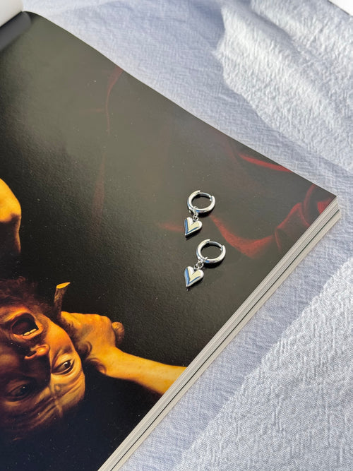 Adore Hoops in silver — fine silver huggie hoop earrings with small silver heart charm, handmade by Salty Gypsy