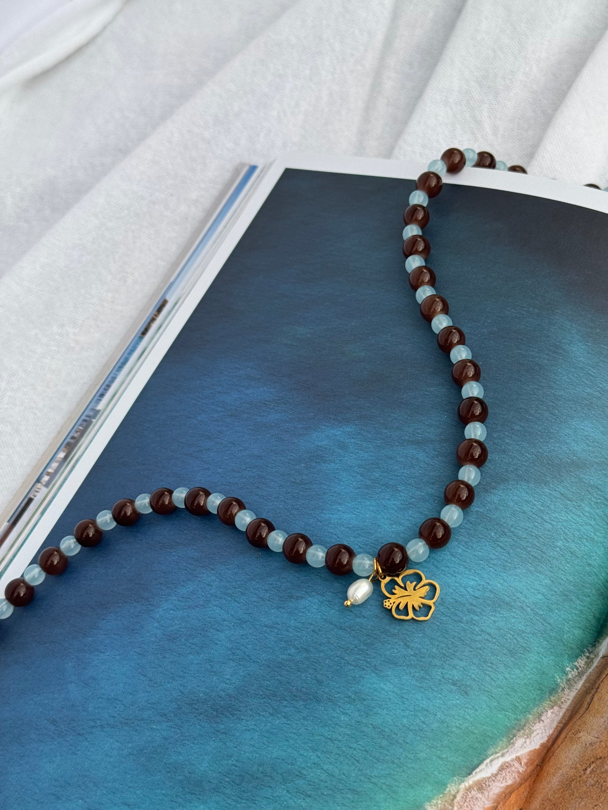 Blue Crush Gold beaded necklace handmade with glass beads, hibiscus charm and rice pearl by Salty Gypsy