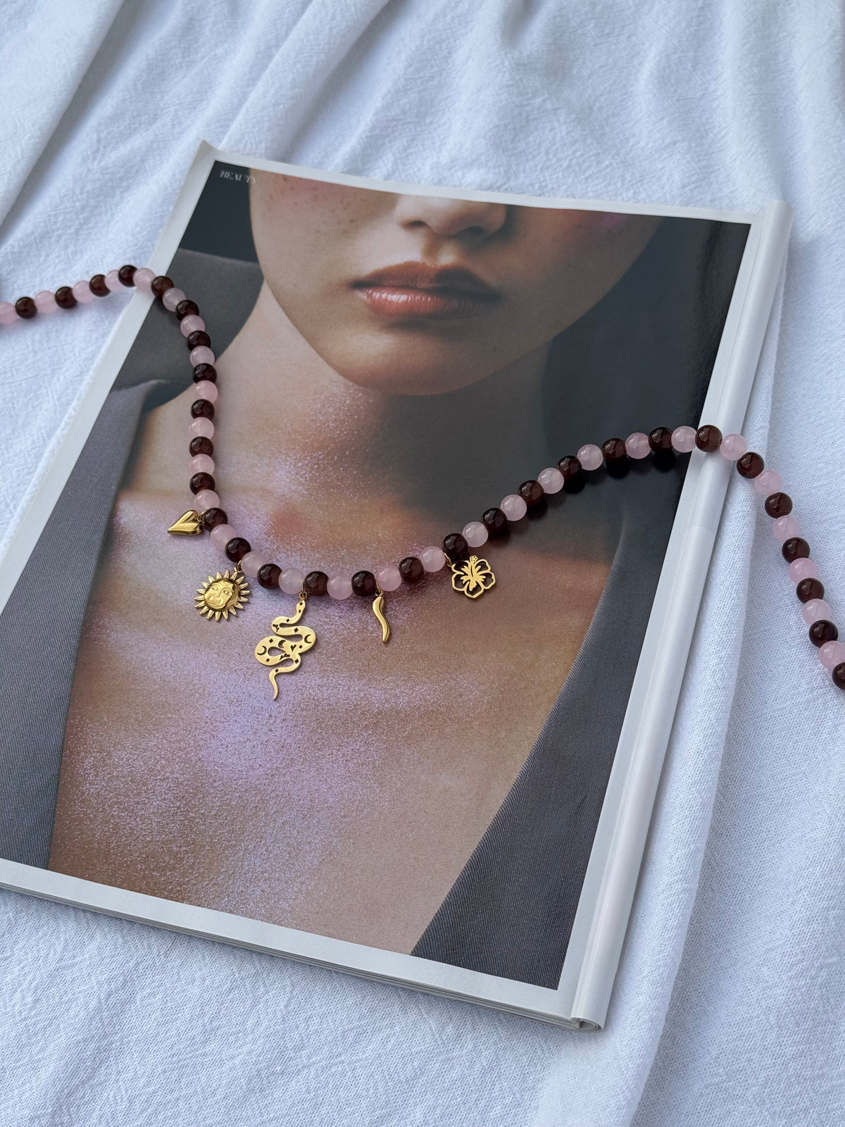 Gold Charmed Necklace — brown and pink glass beads with scattered gold heart, hibiscus, sun, snake and cornicello charms, 49cm, handmade by Salty Gypsy