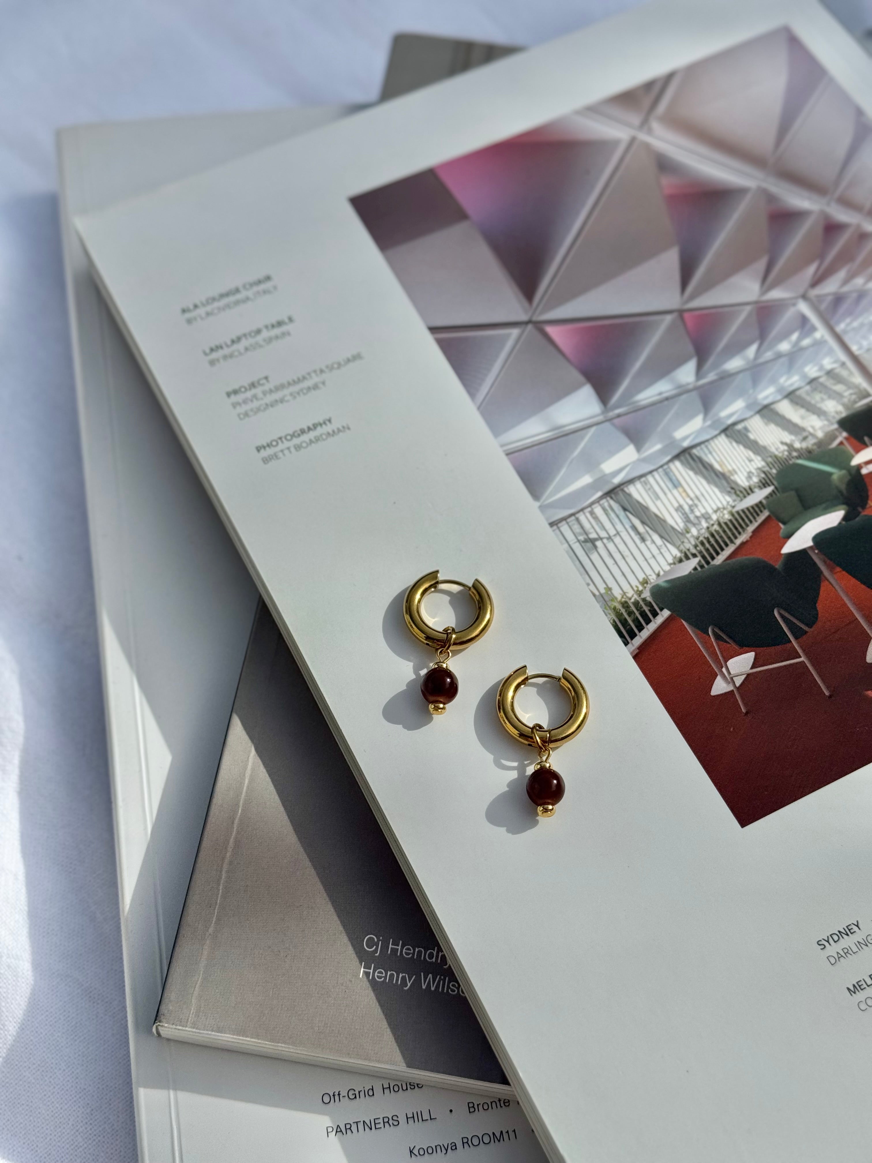 Sloane chunky gold huggie hoop earrings with brown glass bead charm, handmade jewellery by Salty Gypsy